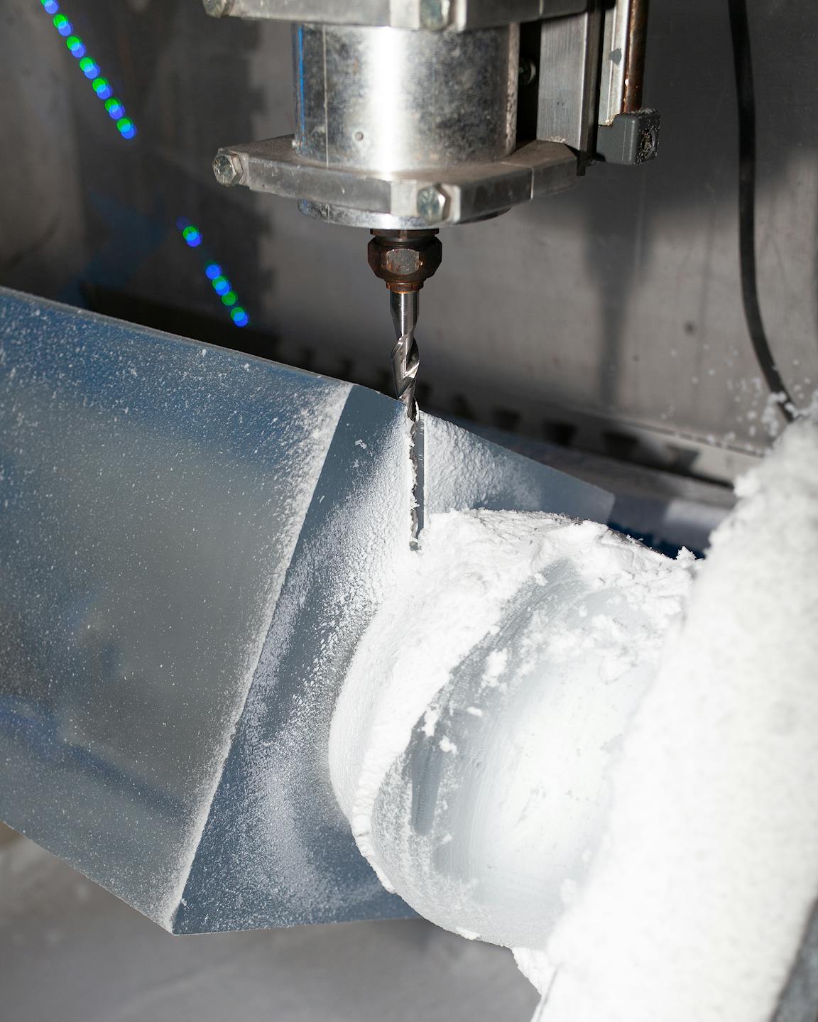 A mechanical drill carves a block of ice.
